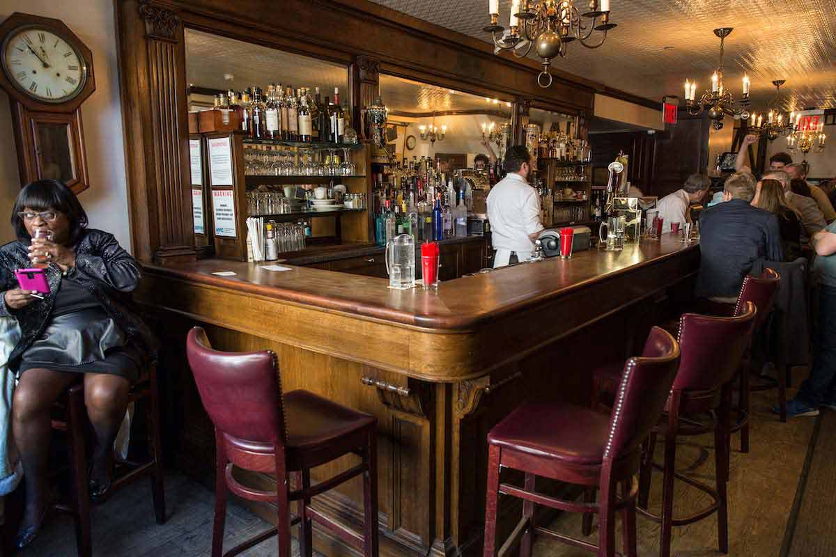 Bar with dark wood paneling and red leather chairs