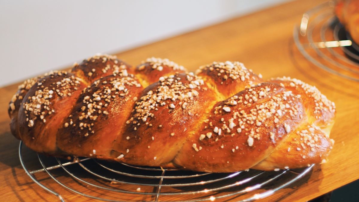 challah bread on metal tray and wooden table