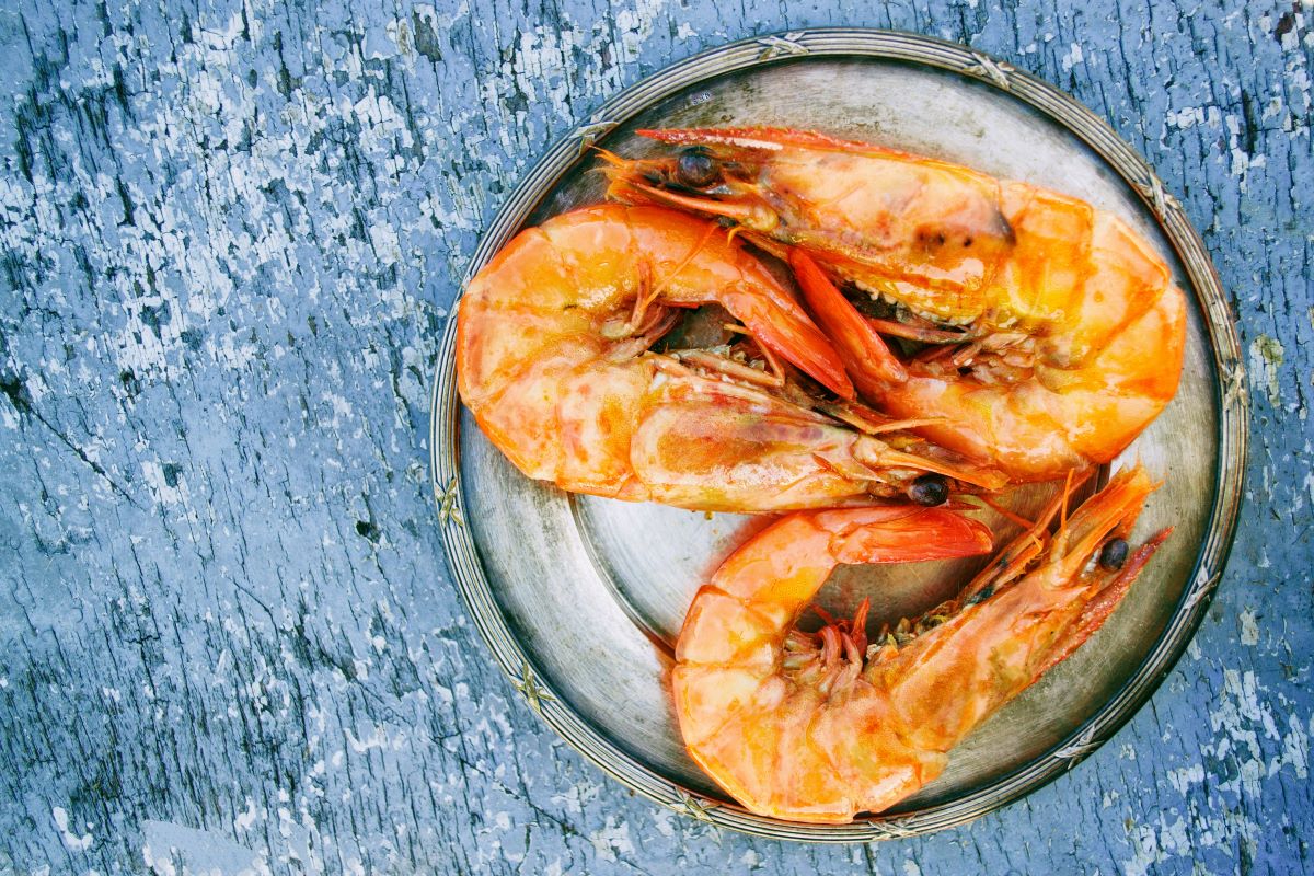 plate of grilled shrimp on on blue wood table