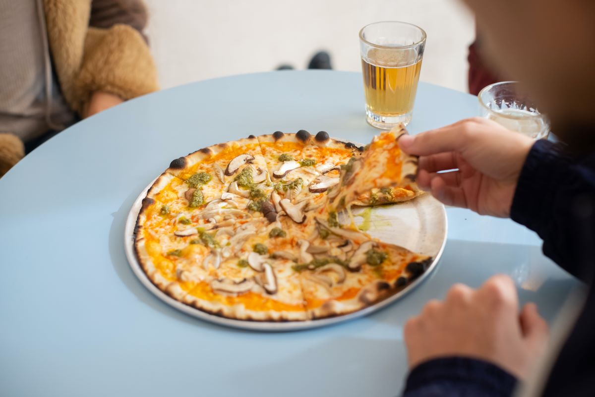 pizza with mushrooms and glass of beer on blue table