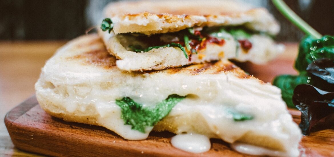 grilled panini sandwich with melted cheese and greens