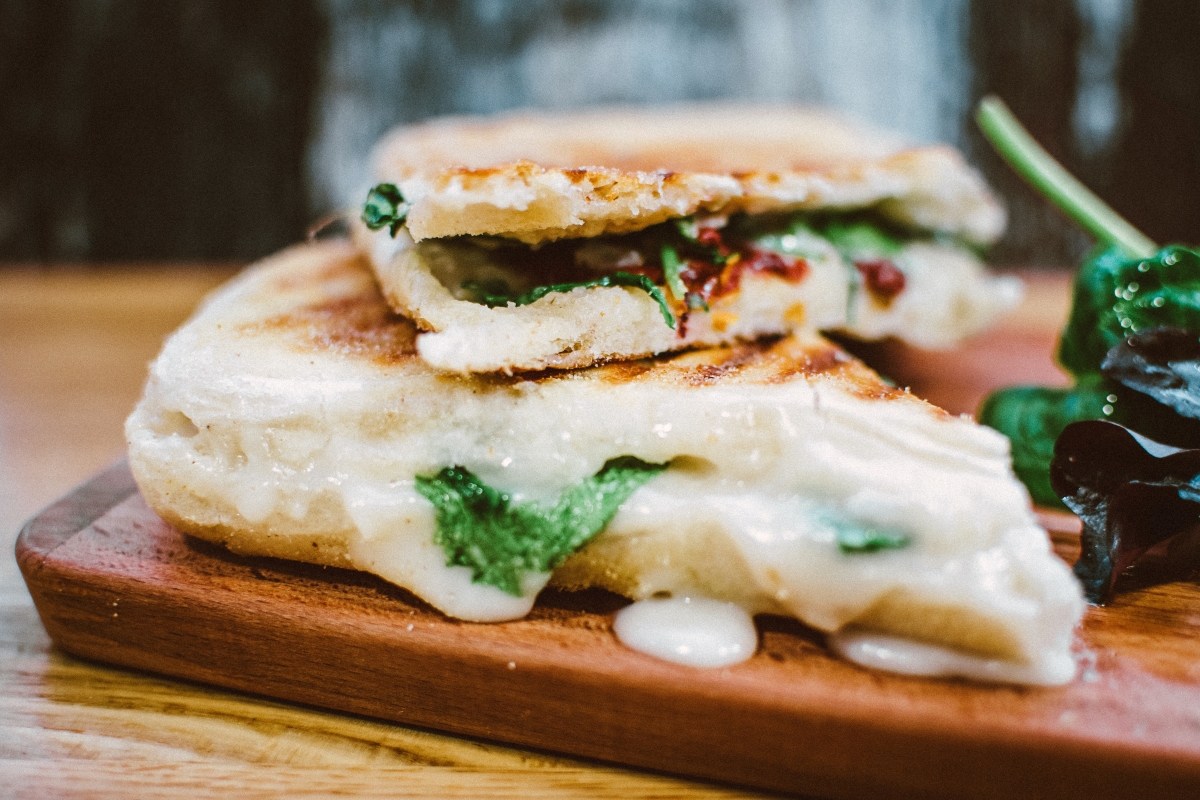 grilled panini sandwich with melted cheese and greens
