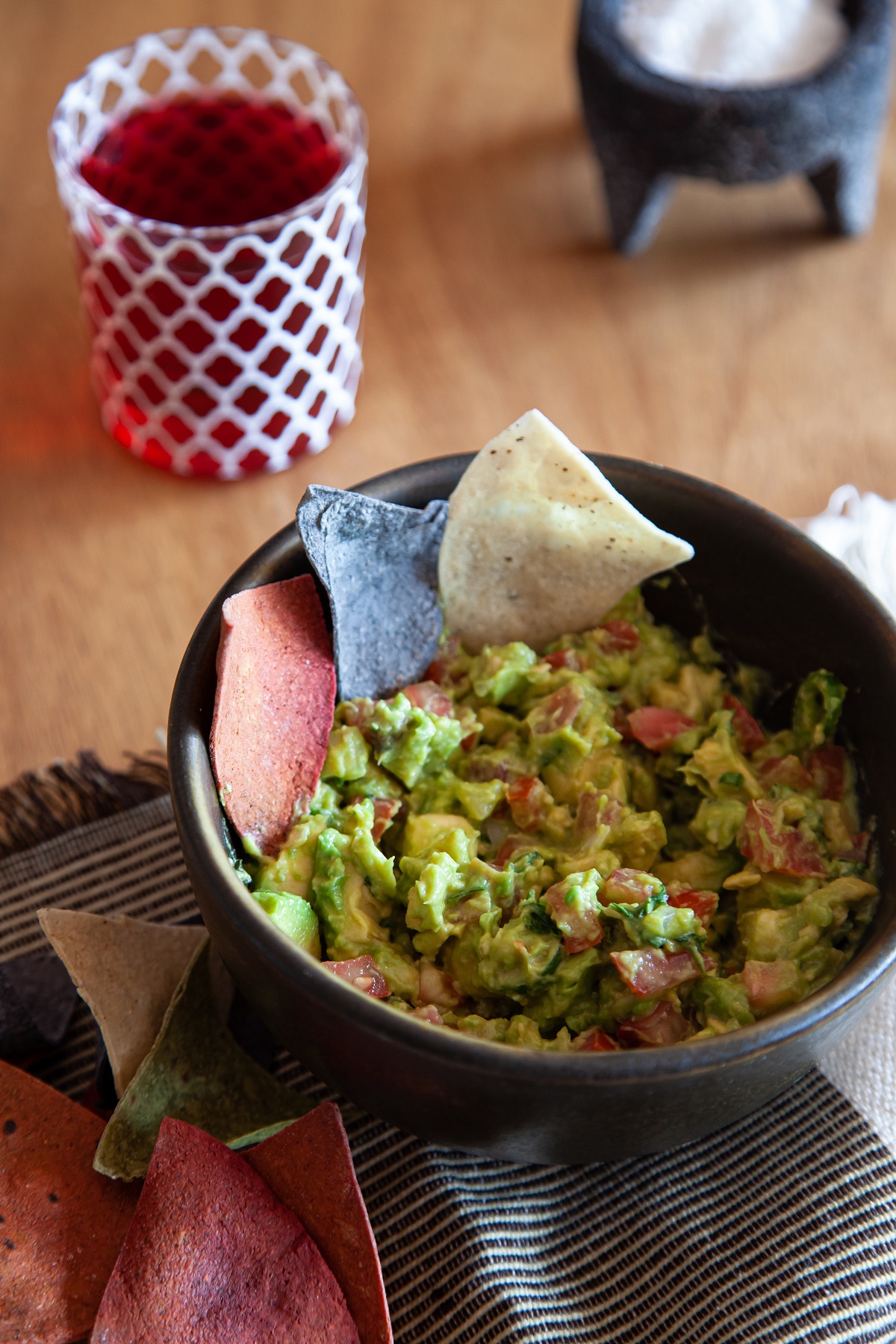 Guacamole and tortilla chips in a black bowl