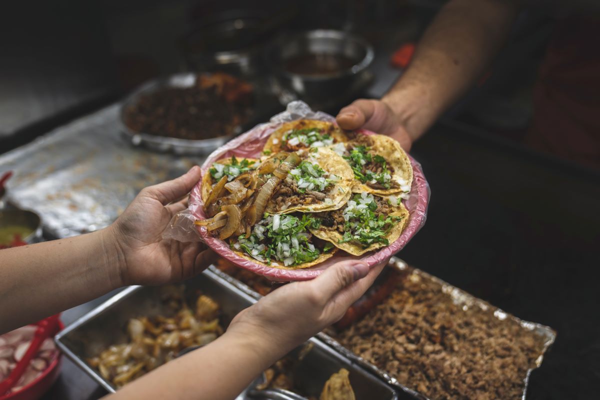 tacos with meat meat and herbs and 3 hands