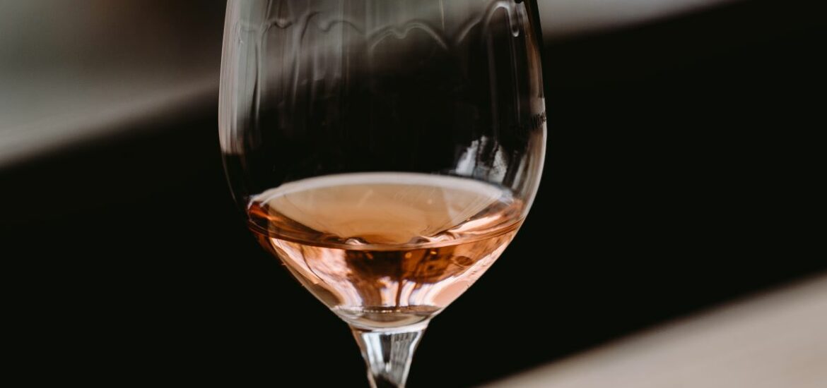 glass of rose wine on wood shelf