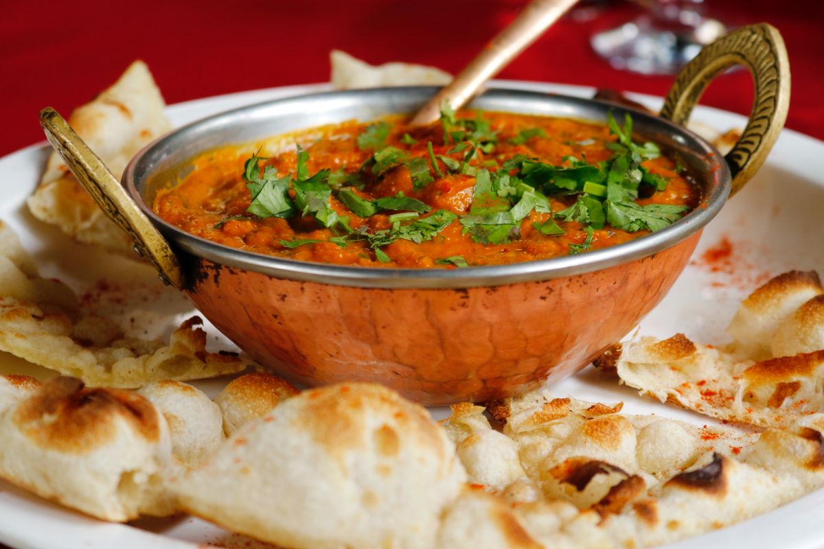 metal bowl with red sauce and flat bread