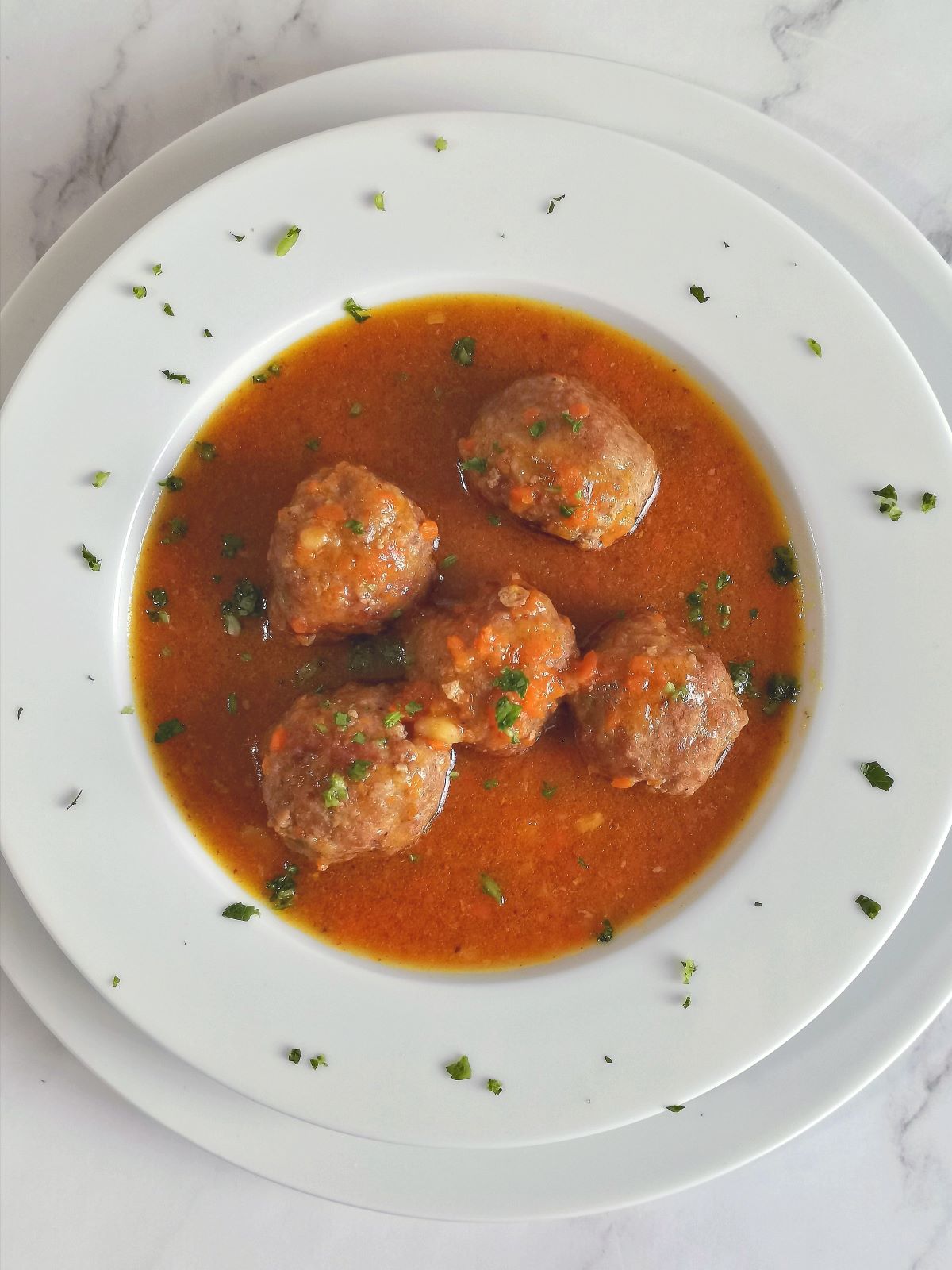 meat balls in red sauce on white plate