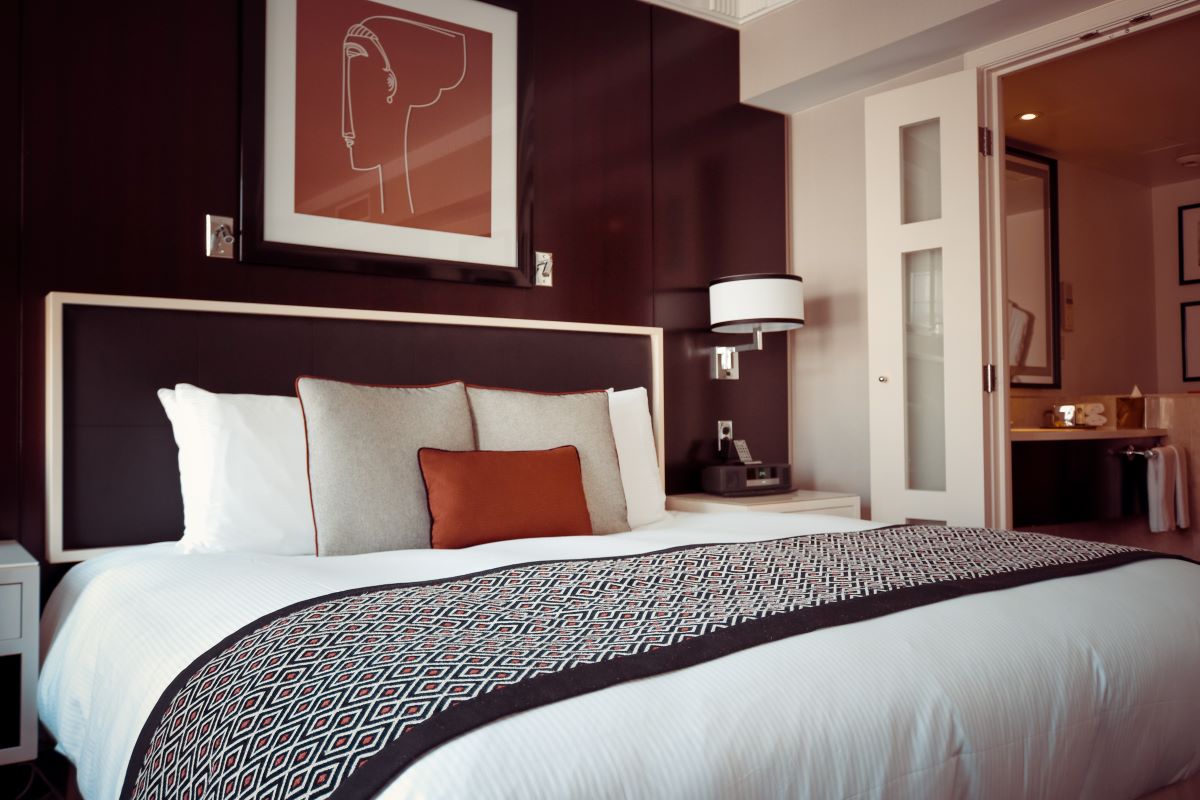 hotel room with brown walls and white bedding 