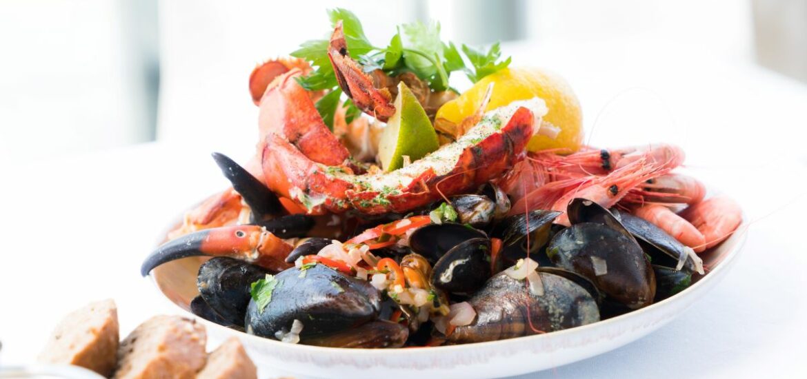 seafood restaurants in new York white plate of mussels and crab on white table cloth and bread