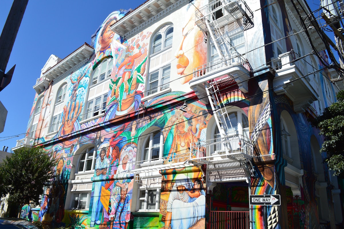 colorful mural of women and female figures on a white building