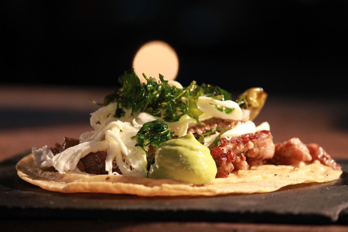 open taco with meat and condiments