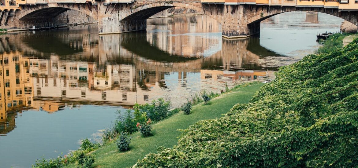 View of Ponte Vecchio bridge in Florence taken from a grassy lawn