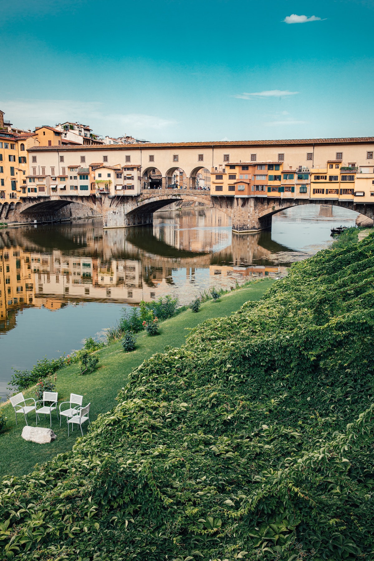 View of Ponte Vecchio bridge in Florence taken from a grassy lawn