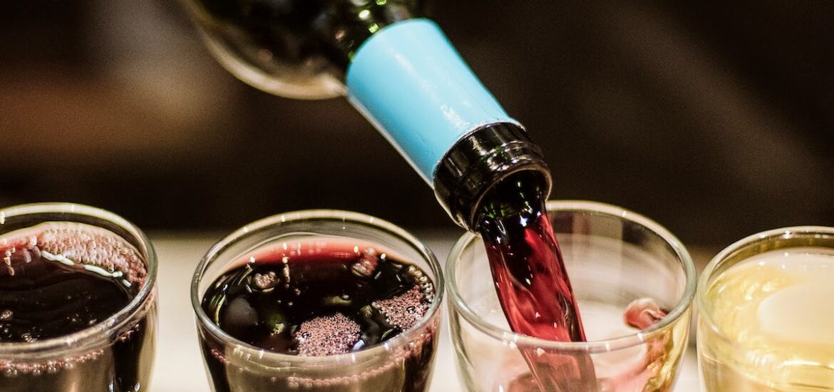 Red wine being poured from a bottle into small chato glasses