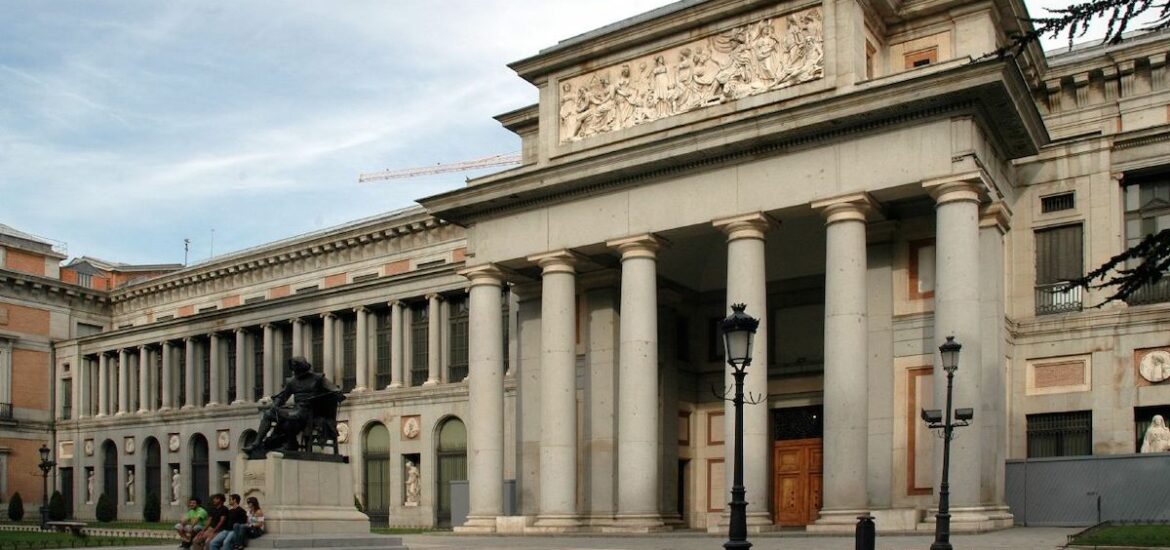 Exterior of the Prado Museum in Madrid decorated with columns, with a statue out in front