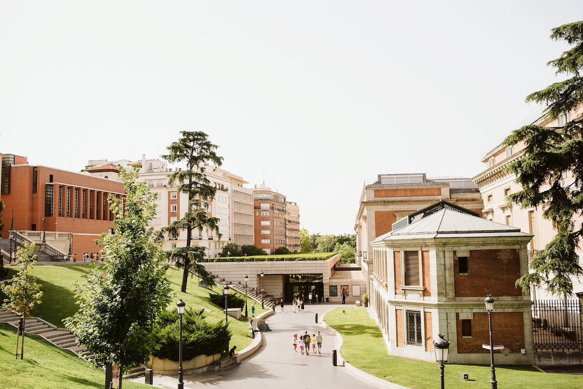 Brick and concrete buildings surrounded by trees and grass.