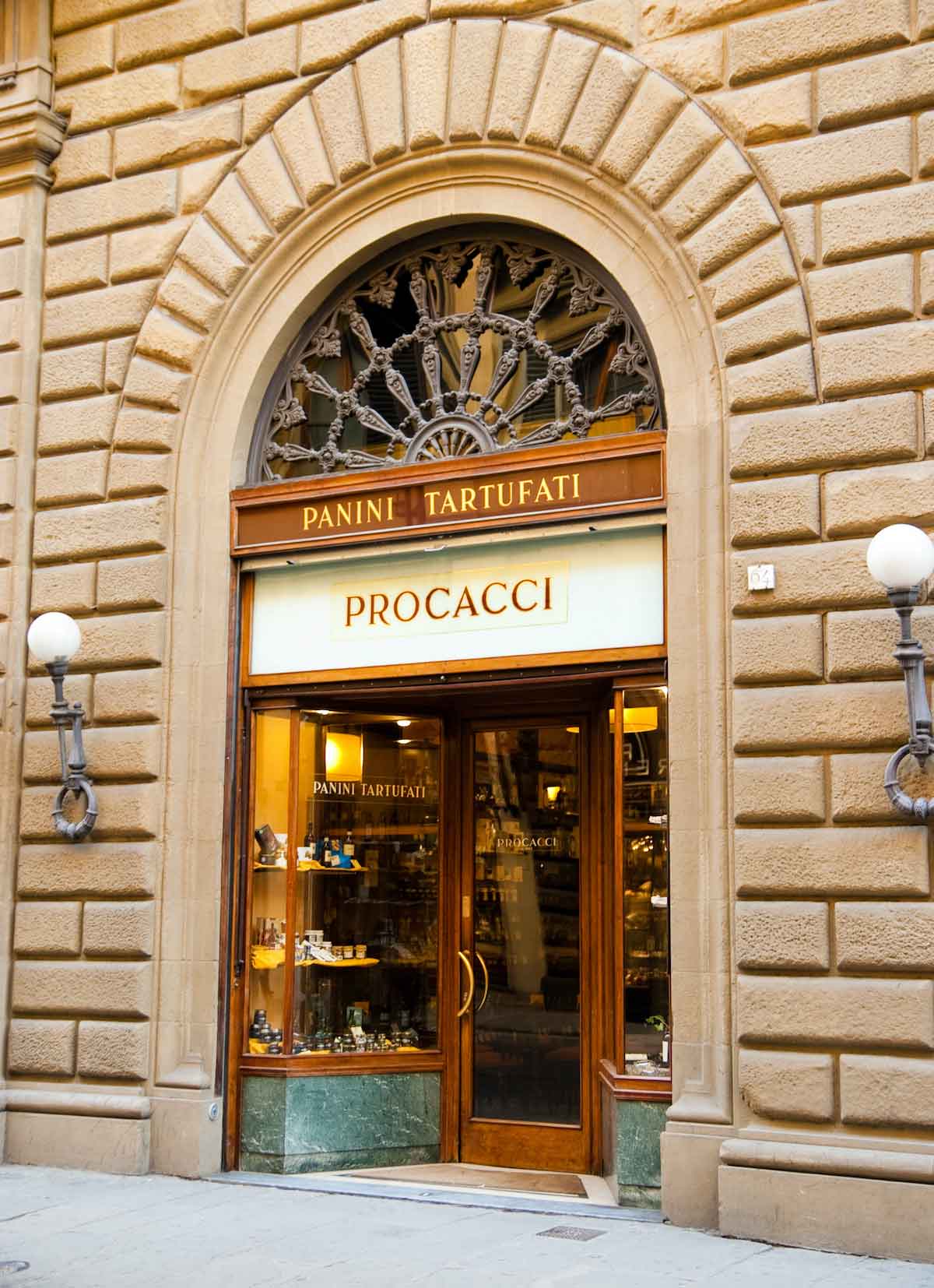 Exterior of Procacci restaurant and wine bar in Florence with an arched stone doorway