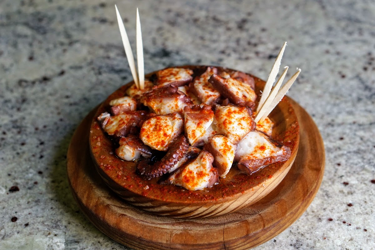 Clay dish of diced octopus sprinkled with paprika, to be eaten with toothpicks.
