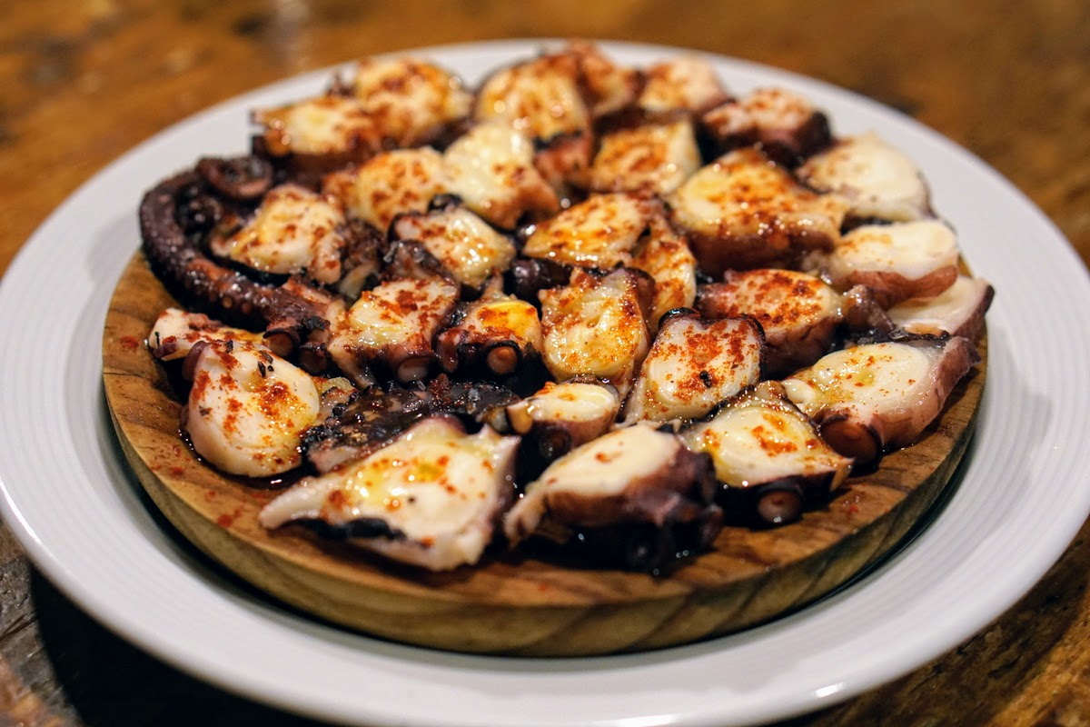 Octopus seasoned with paprika served on a wooden plate