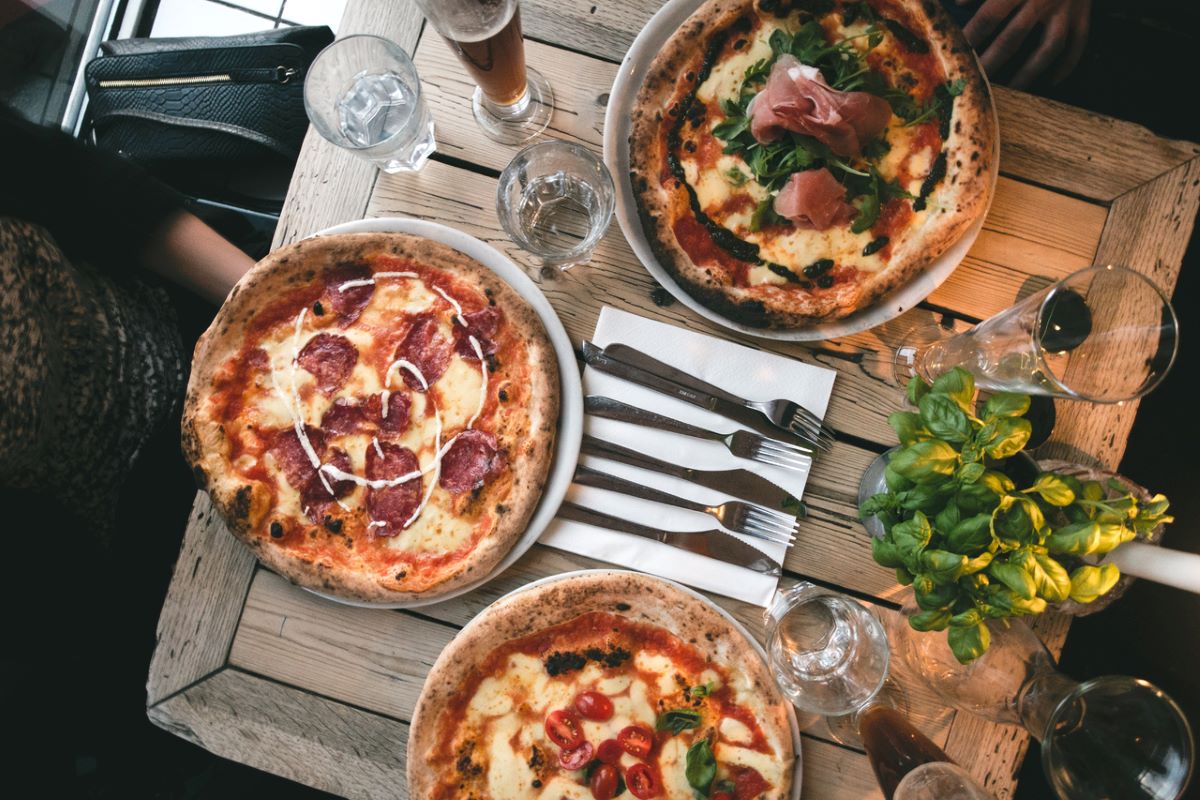 pizzas on wooden table next to beer
