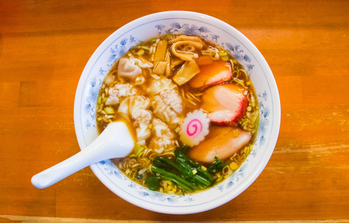 Overhead shot of ramen with meat and vegetables in a white bowl