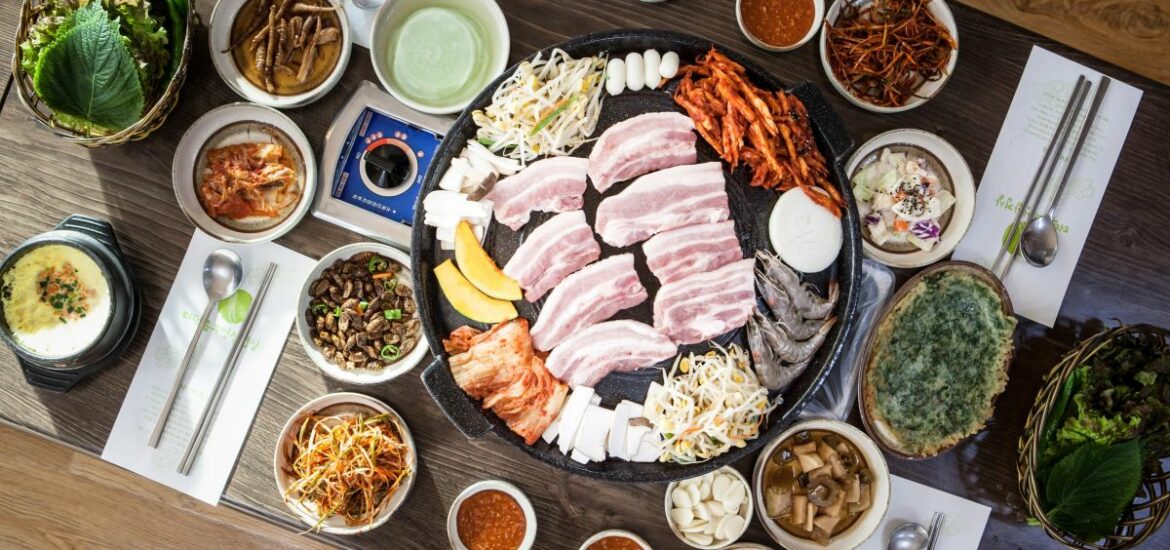 table with many different plates and korean bbq