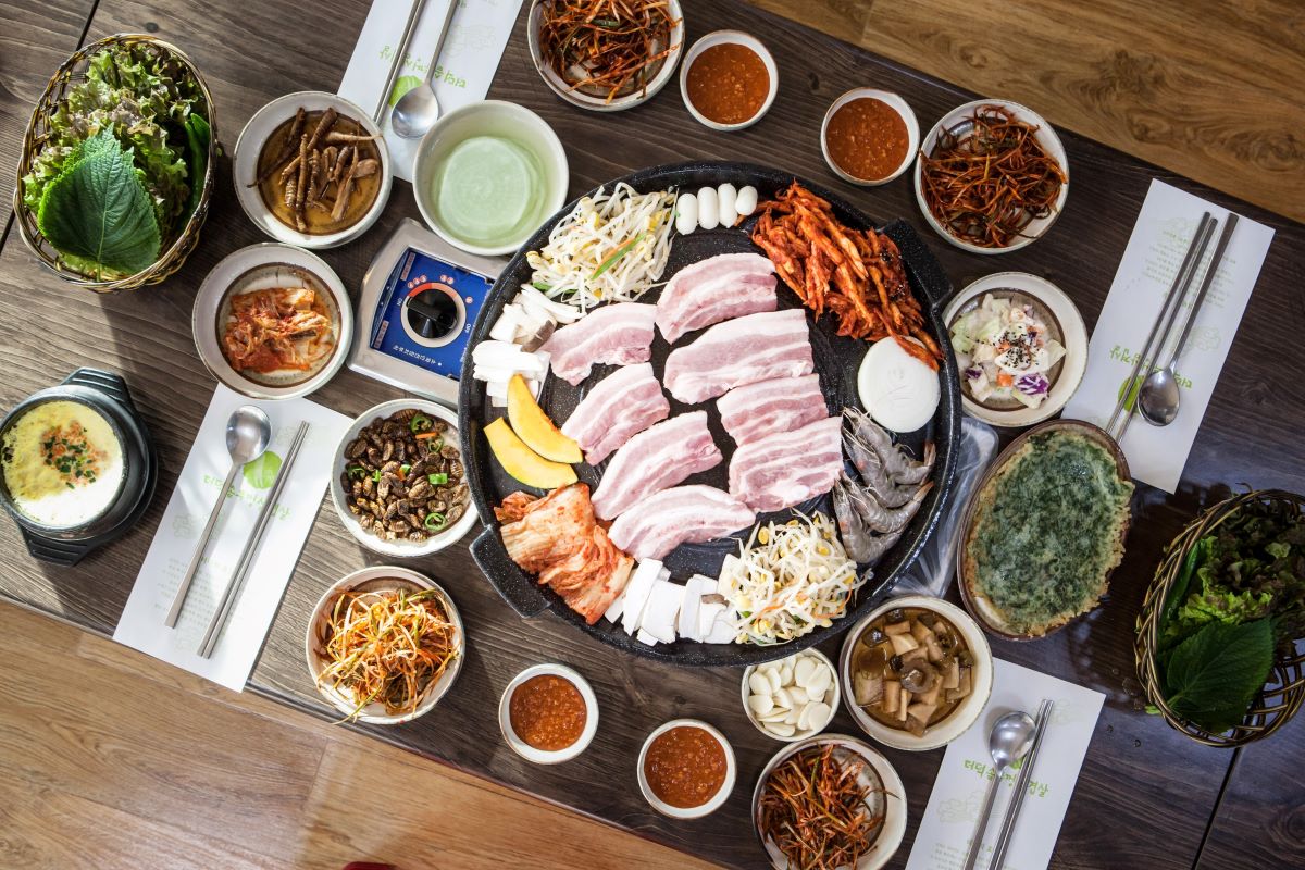 table with many different plates and korean bbq 