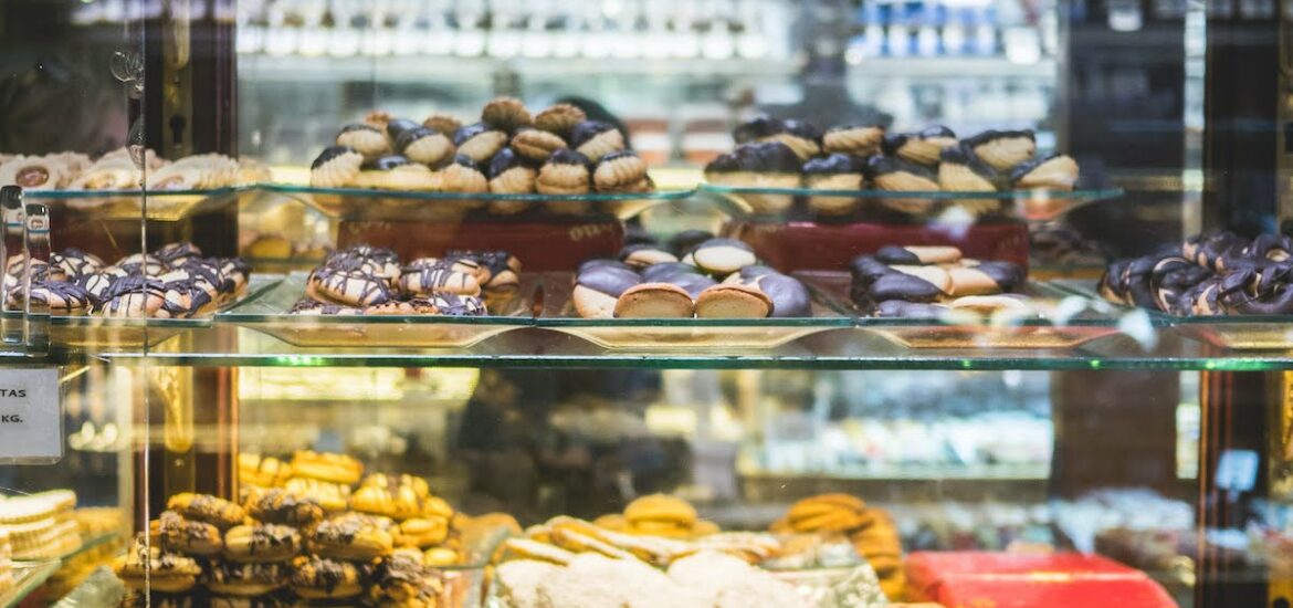 Cookies and pastries on display behind a glass case at a bakery.