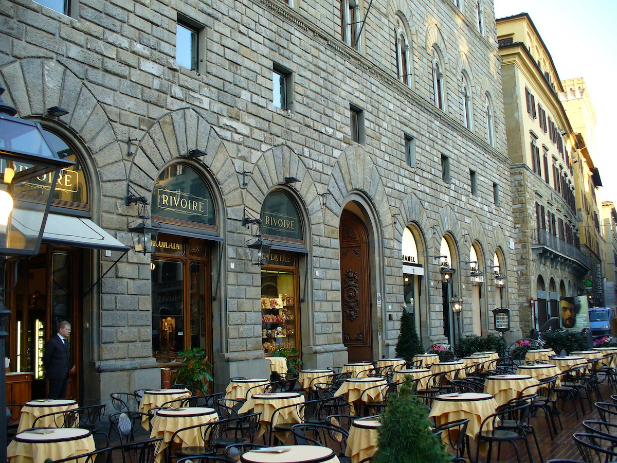 Outdoor cafe terrace outside a large stone building