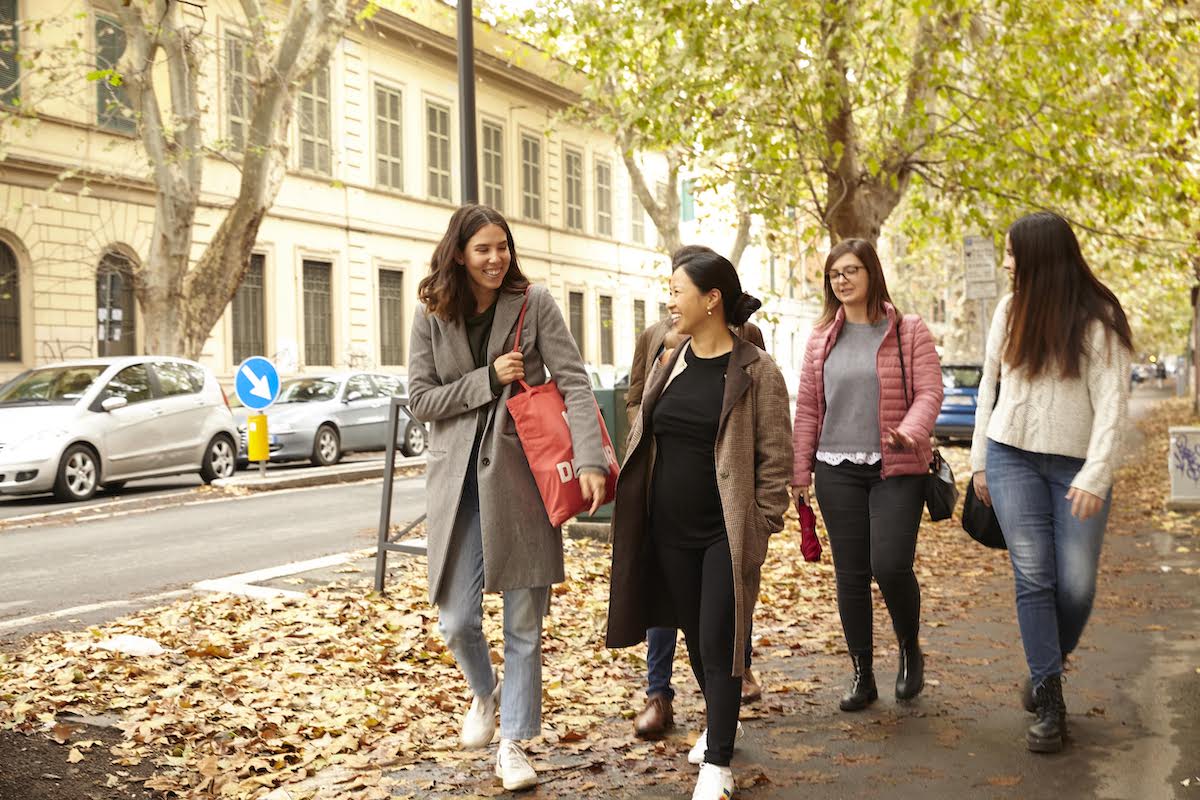 Four women walking on a city street in the fall