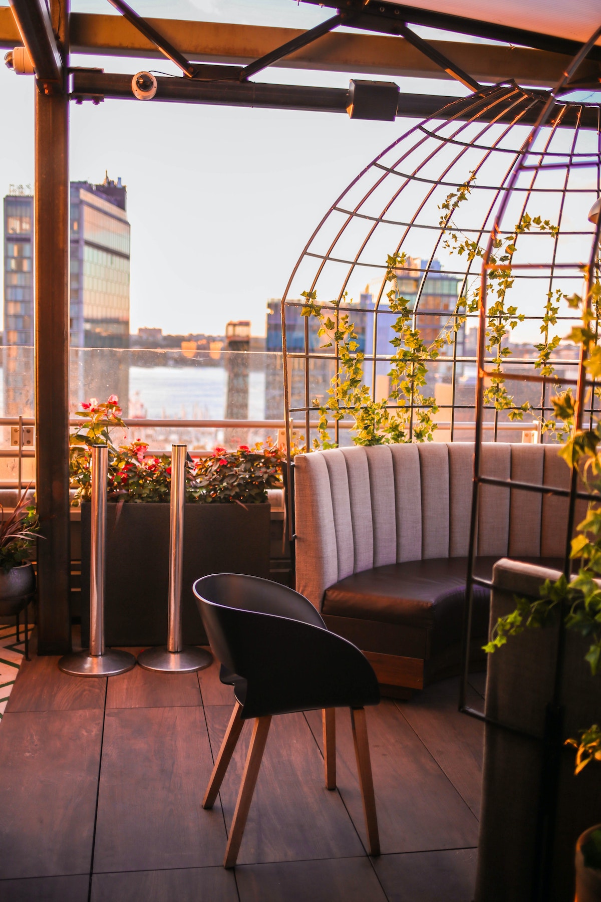 Booth at a rooftop bar decorated with plants and flowers