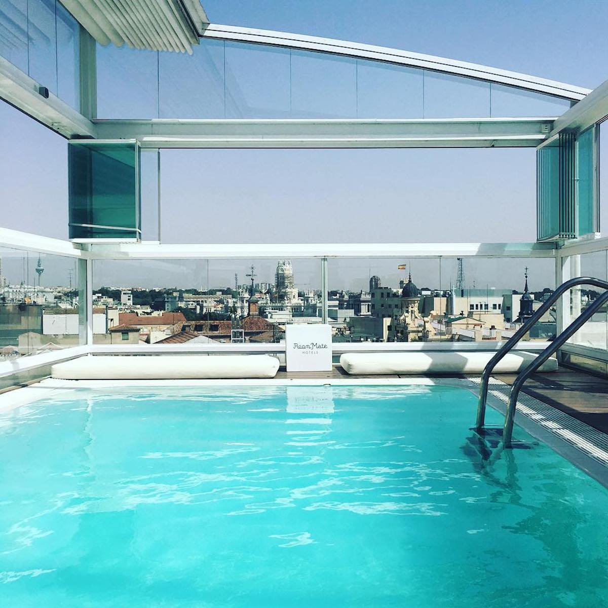 Rooftop pool on top of Room Mate Oscar hotel in Madrid with view of the city skyline.