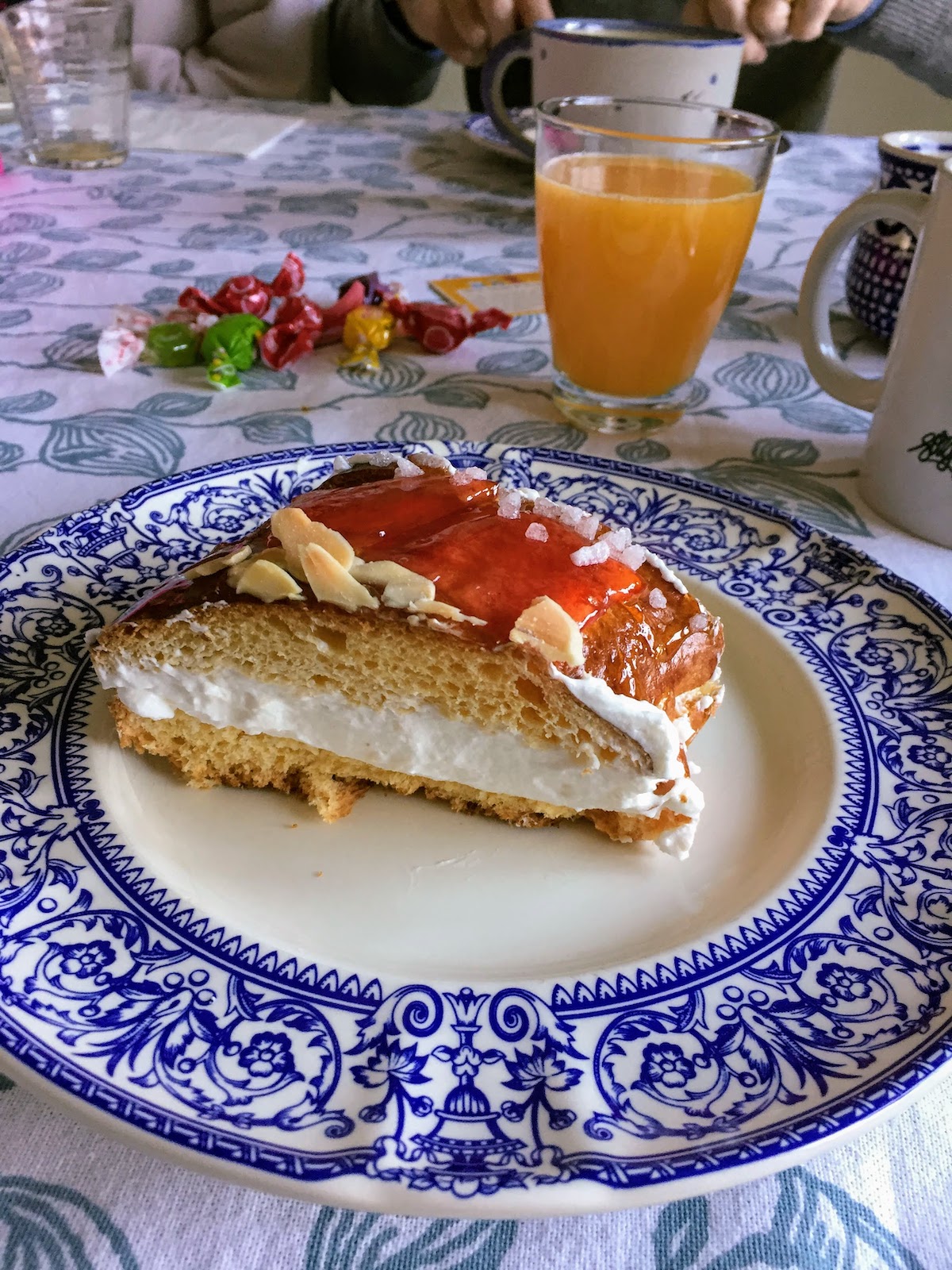 Slice of Spanish kings day cake, or roscón de reyes, on a blue and white plate.