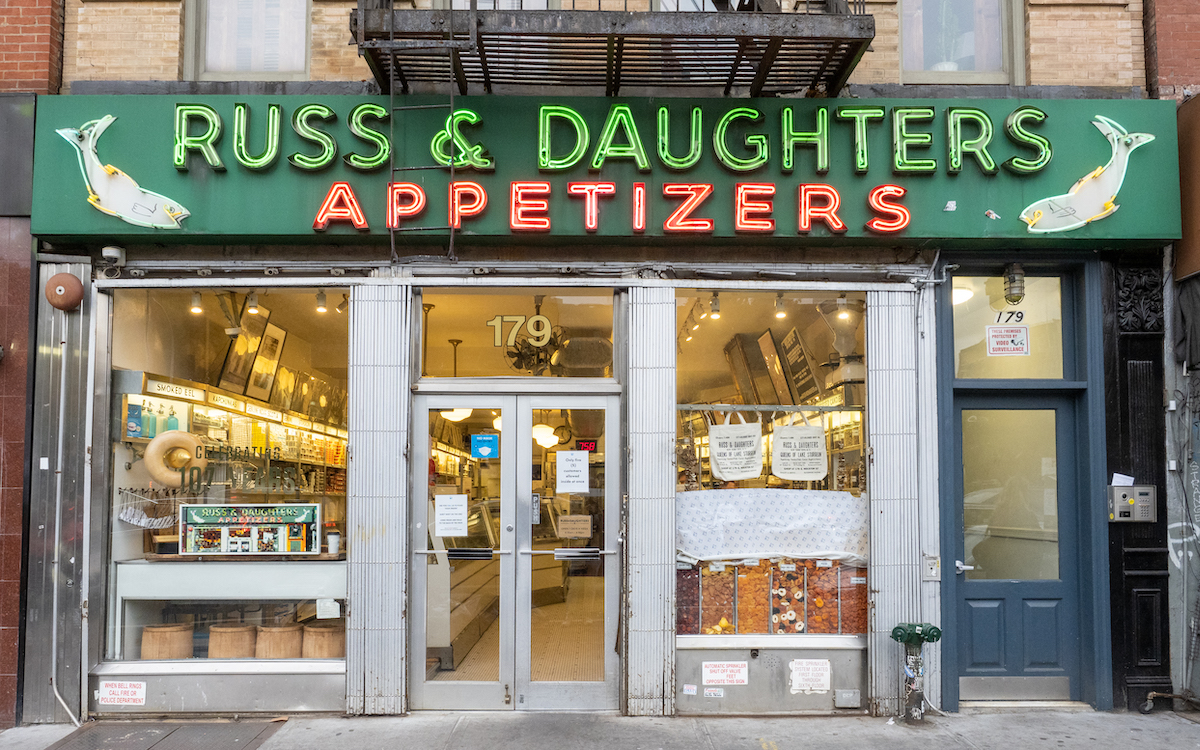 Front of Russ & Daughters deli in NYC with a green and red sign above the doorway.