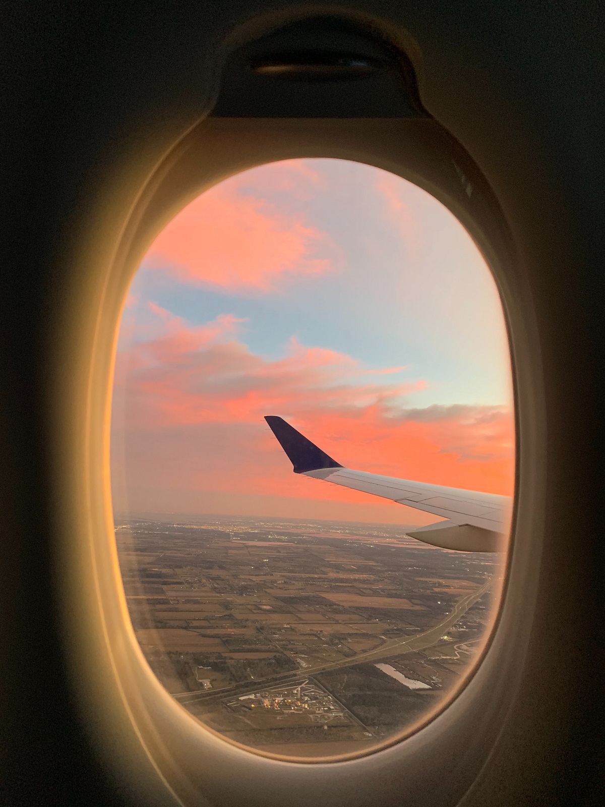 View of ground below from a seat on an airplane by a window