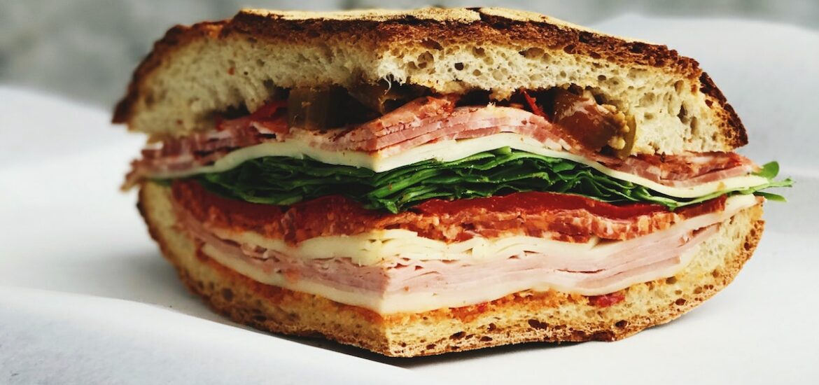 Close up of a sandwich filled with deli meats and cold cuts.