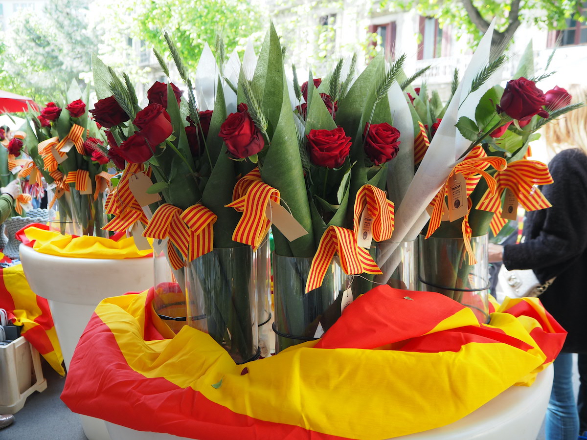 Roses for sale decorated with red and yellow striped flags.