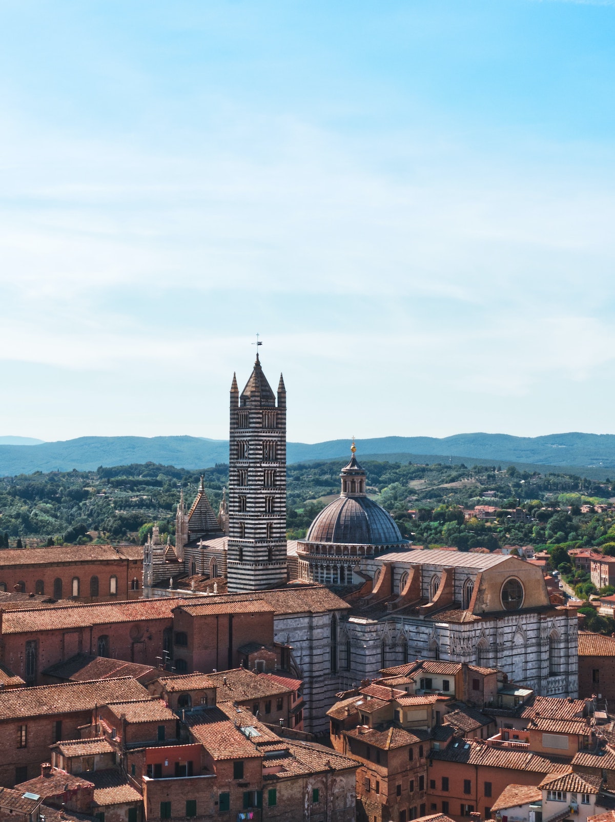 Aerial photo of Siena, Italy, with its cathedral and bell tower prominently featured