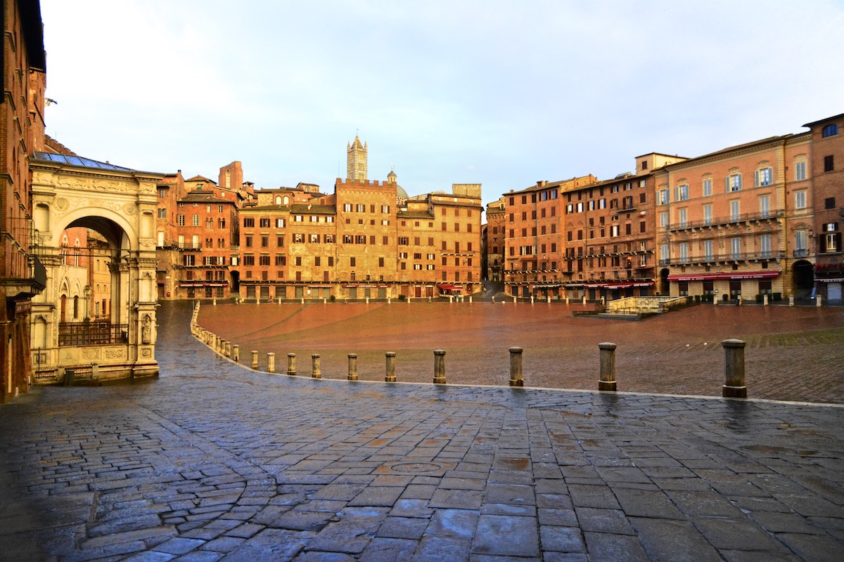 Italian piazza surrounded by medieval buildings at sunrise