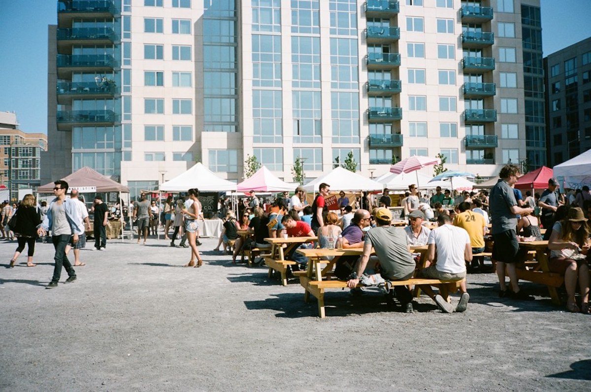 People eating at picnic tables in an urban area