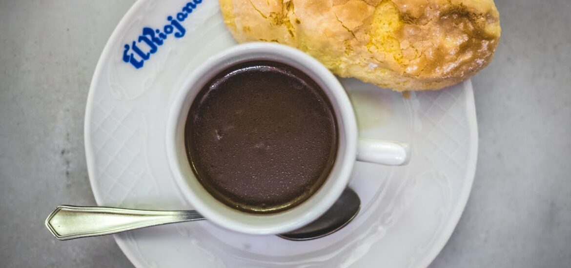 Overhead shot of a mug of thick hot chocolate with a ladyfinger cookie.