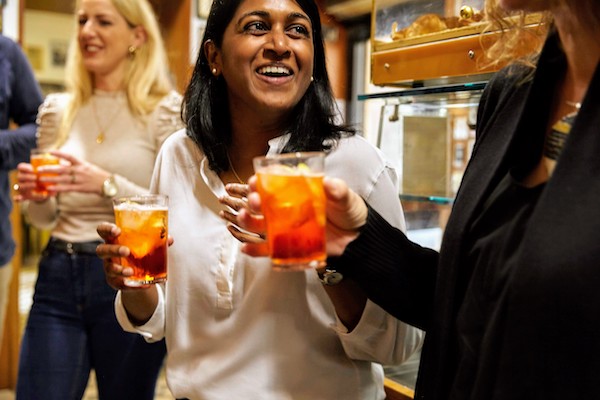 Group drinking Aperol spritzes at a bar in Rome
