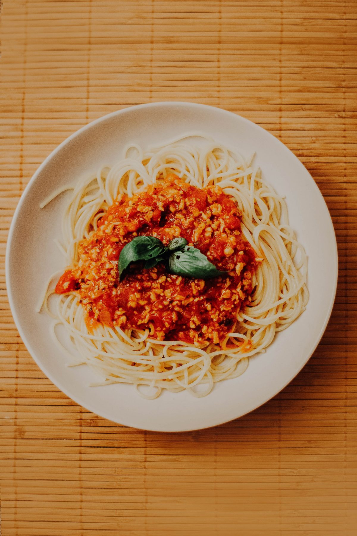 Overhead shot of spaghetti bolognese on a white plate.