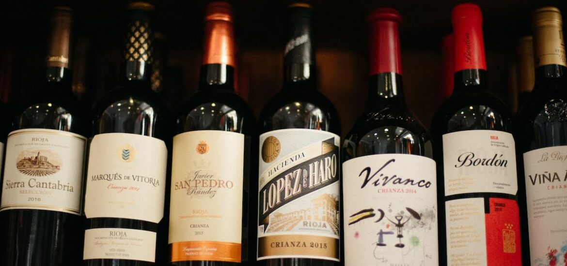 Seven Spanish wine bottles lined up on a shelf.