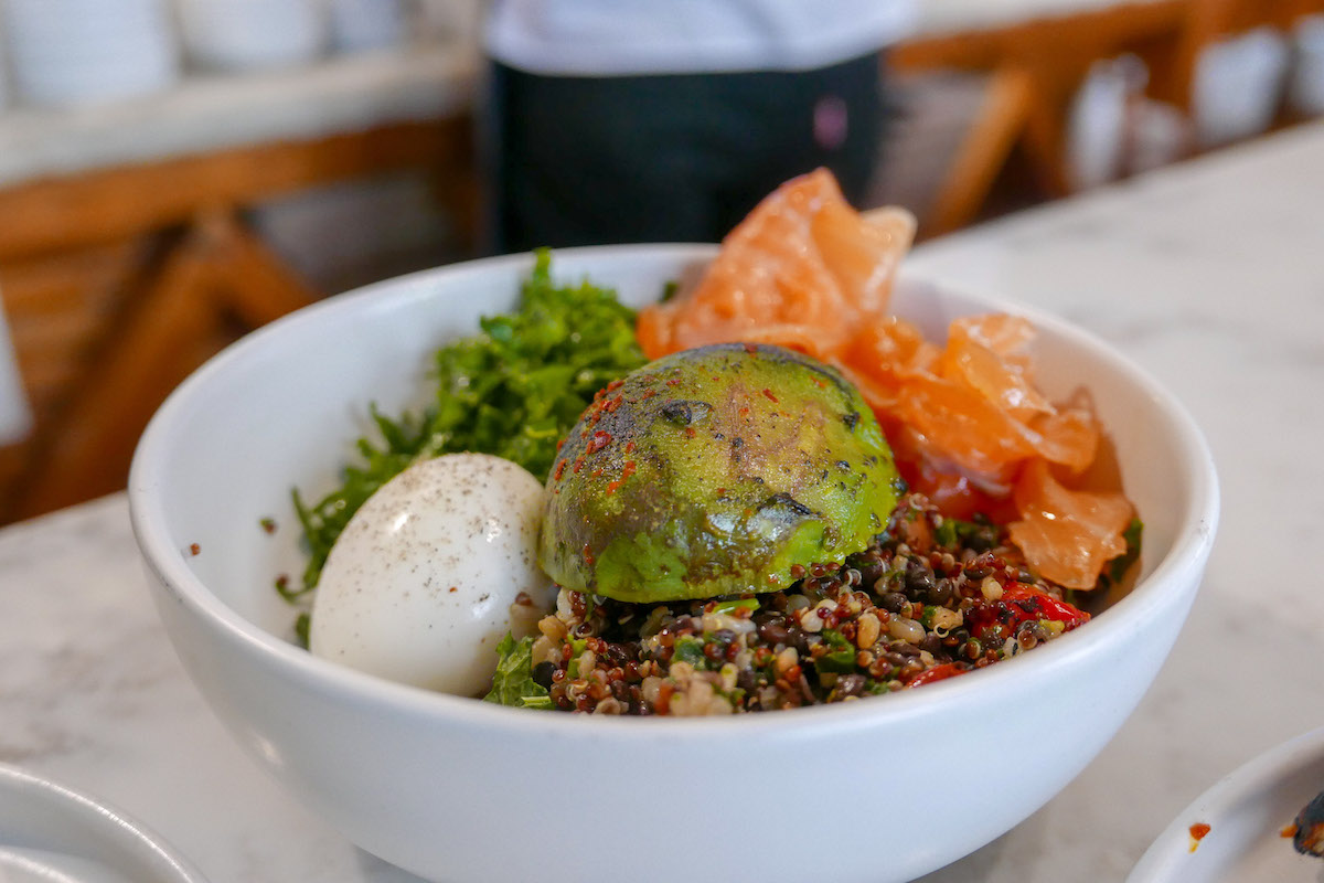Quinoa and lentil bowl with egg, kale, salmon, and avocado