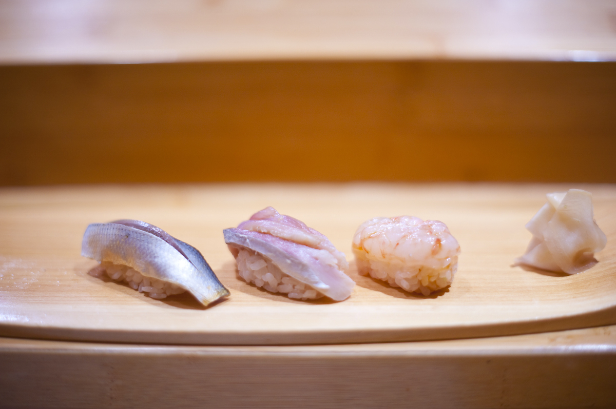Four pieces of sushi on a wooden serving tray