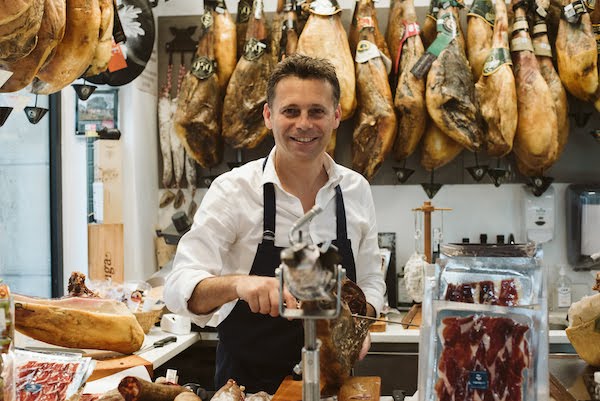 Sylvain, owner of Zapore Jai gourmet shop, cutting Iberian ham
