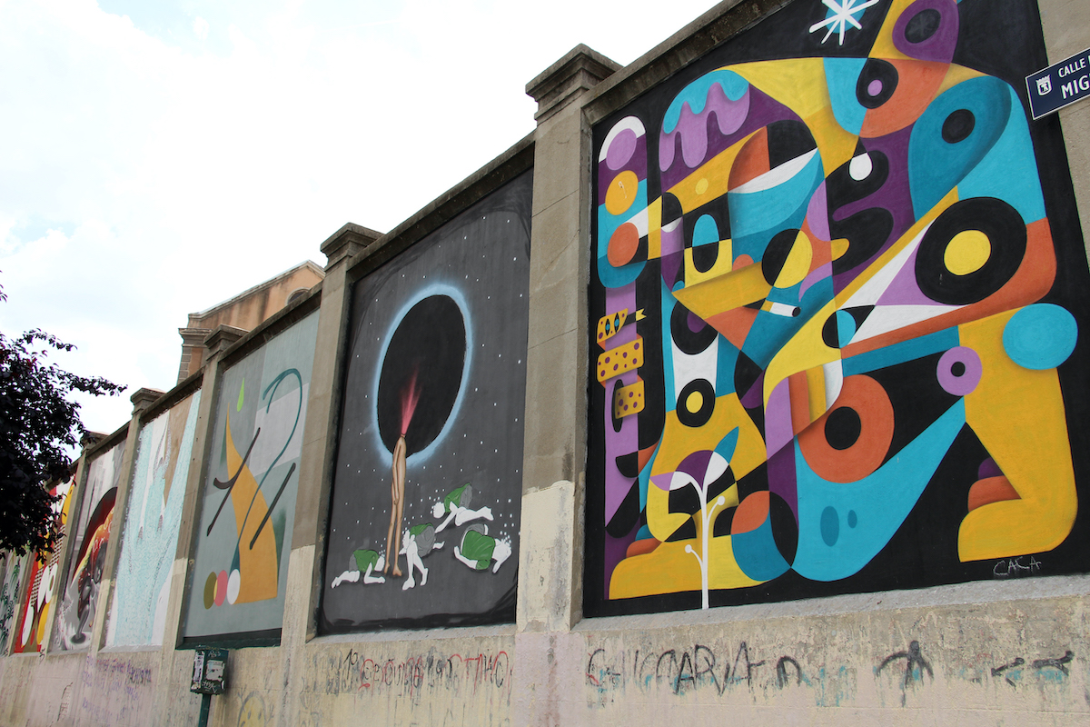 Set of colorful abstract murals painted on an exterior concrete wall.