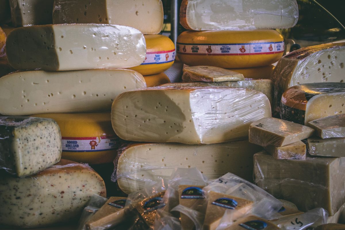 A variety of cheese sitting in a display case