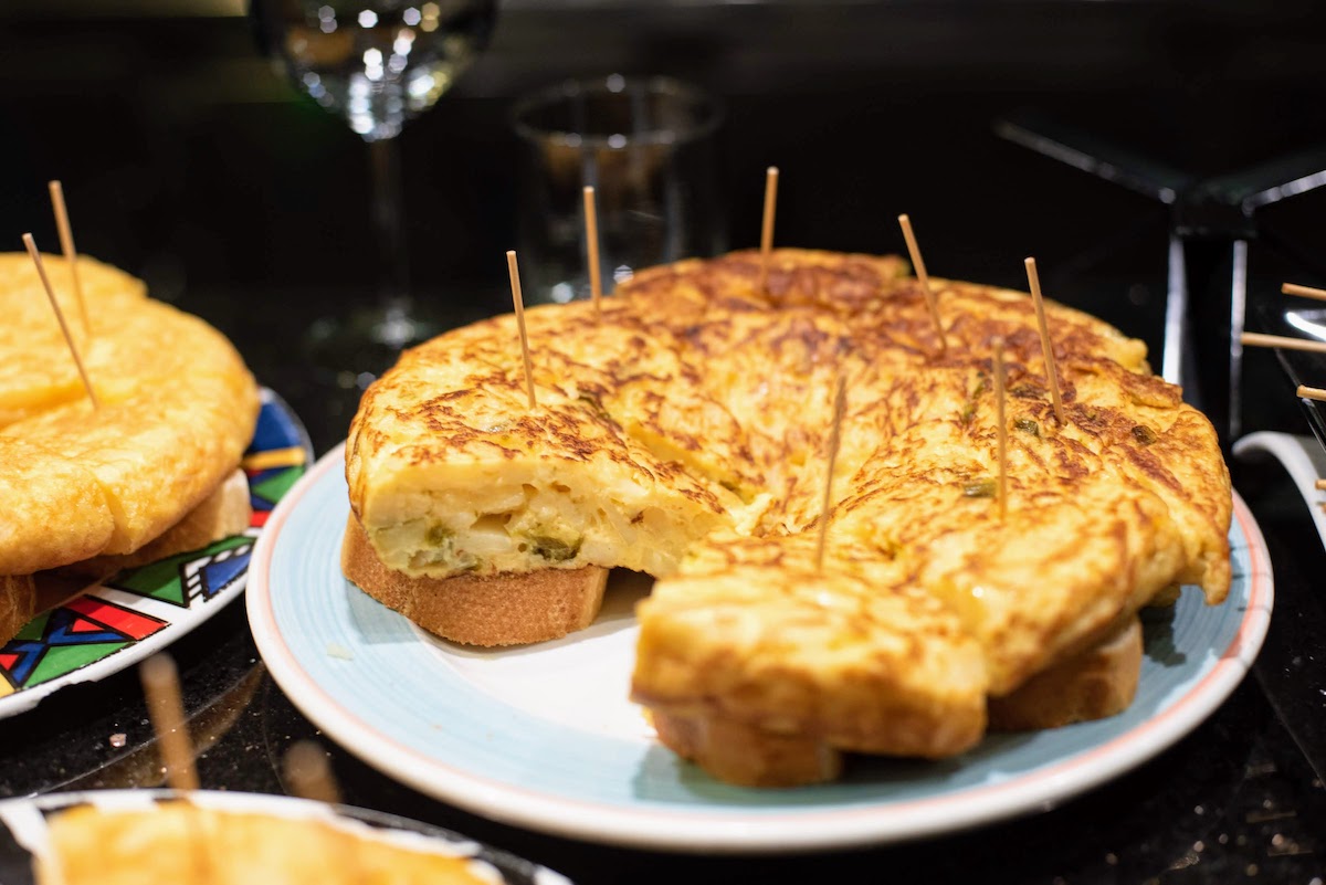 Slices of potato and pepper omelet served atop small pieces of bread